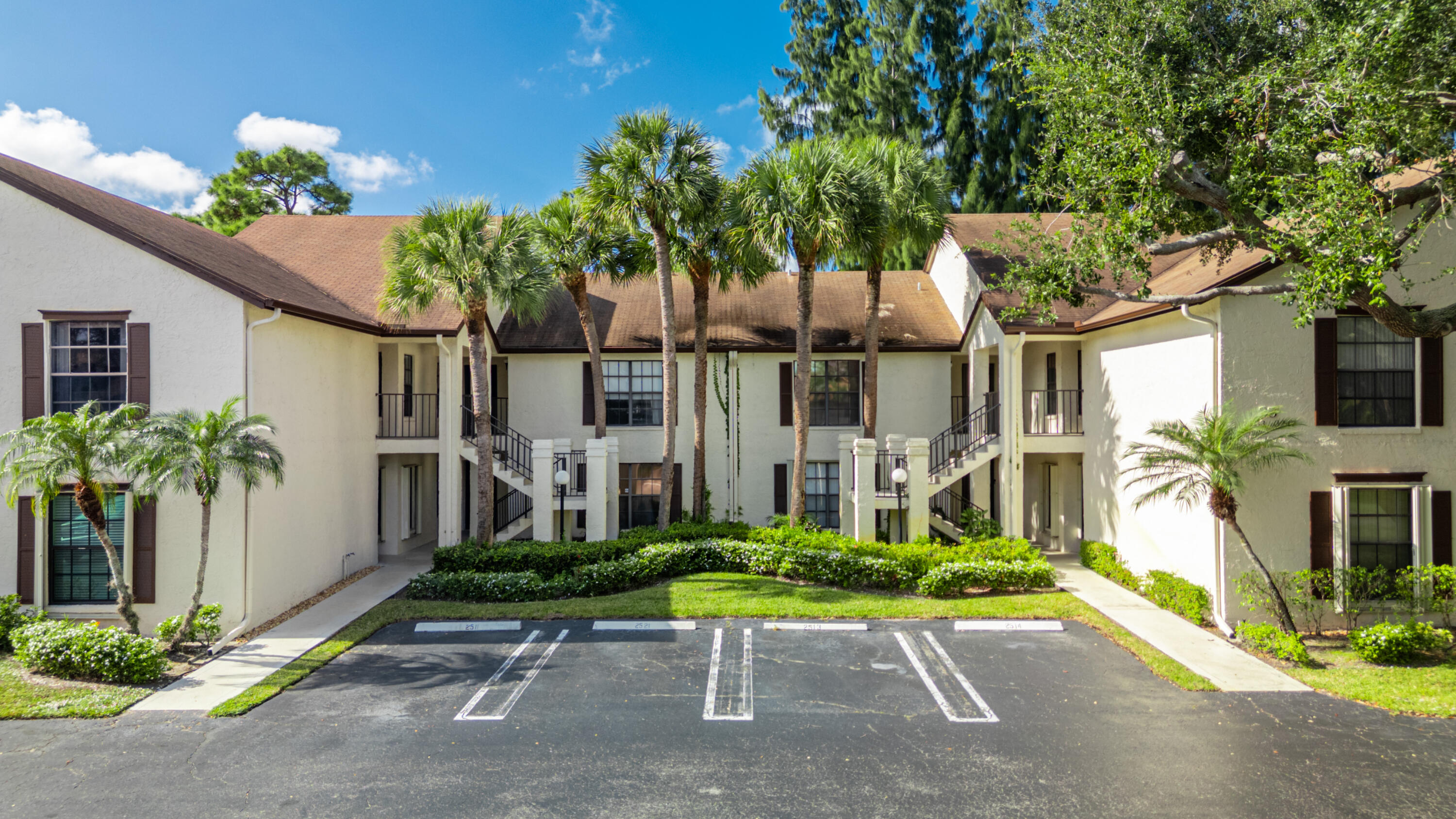 3233 Perimeter Drive, Unit 2511 Greenacres, FL 33467 - Photo 2 of 39 a house with a bench in front of it