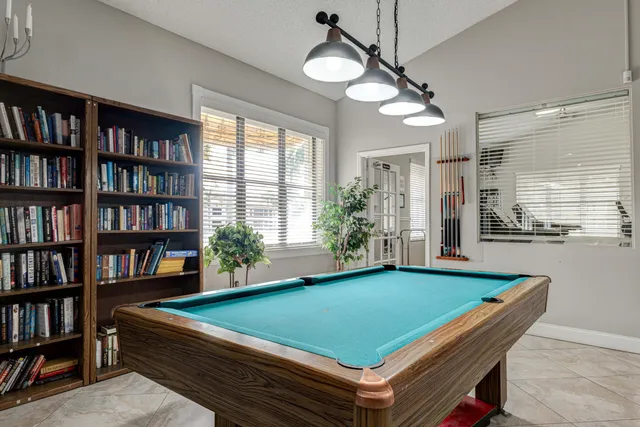 a room with pool table and windows