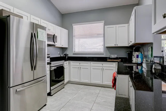 a kitchen with stainless steel appliances granite countertop a refrigerator sink and stove