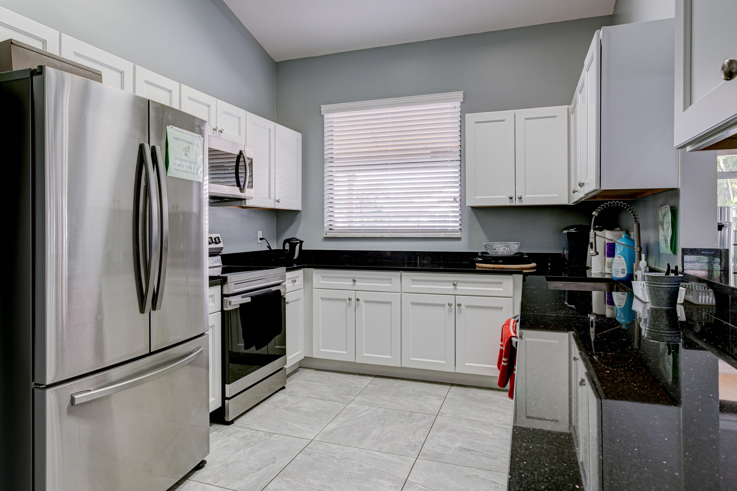 3233 Perimeter Drive, Unit 2511 Greenacres, FL 33467 - Photo 29 of 39 a kitchen with stainless steel appliances granite countertop a refrigerator sink and stove