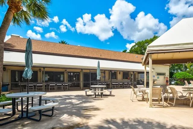 a view of a patio with dining table and chairs with a large tree