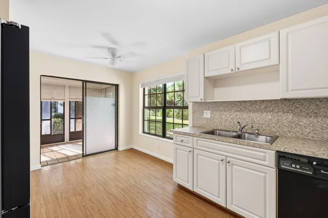 a kitchen with a sink cabinets stainless steel appliances and a window
