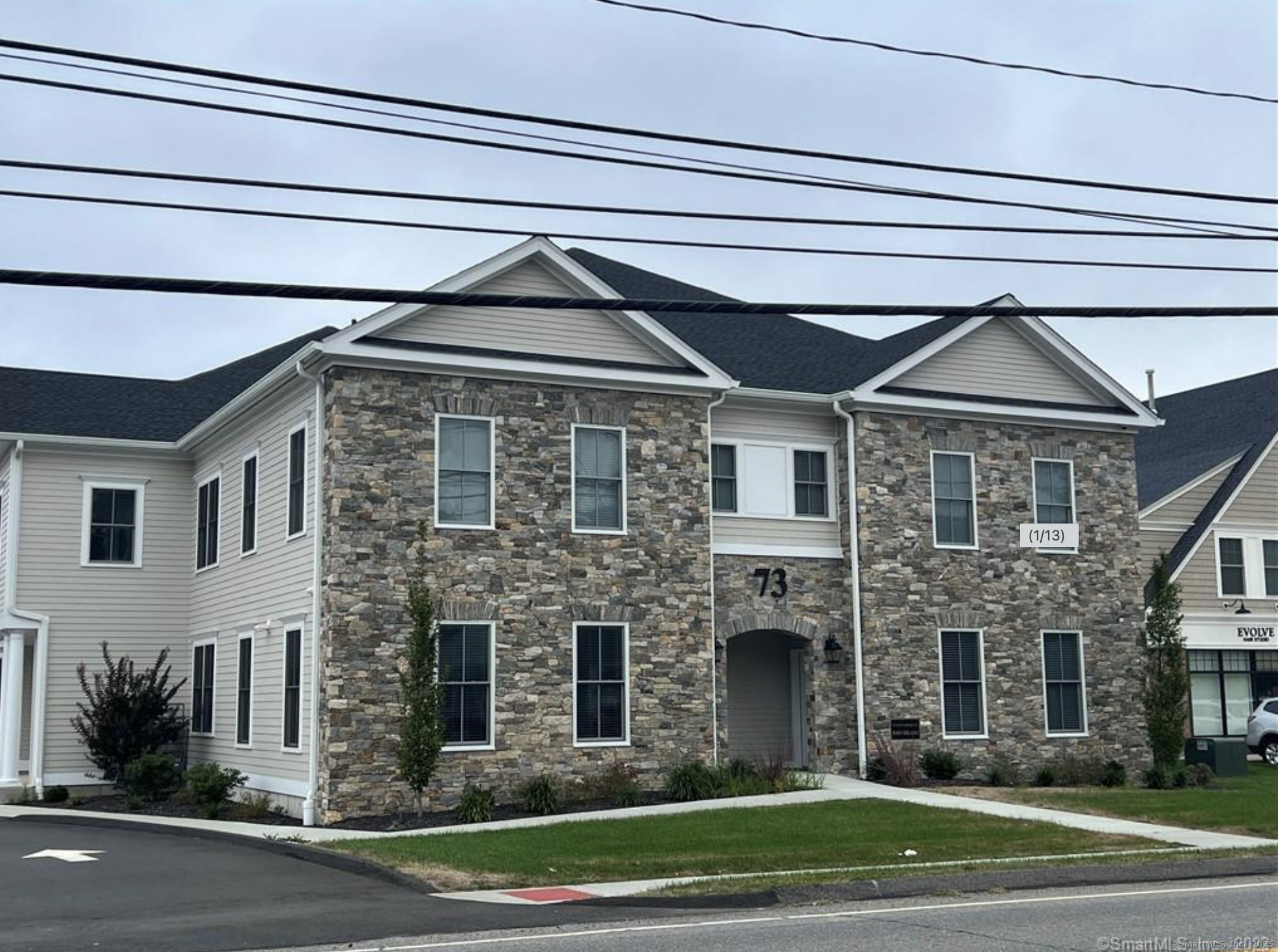 73 West Main Street, Unit 5 Clinton, CT 06413 - Photo 23 of 23 a front view of a house with a garden and garage
