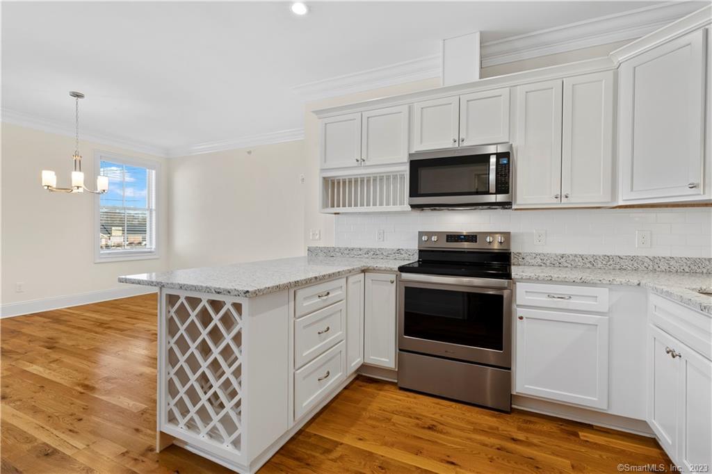73 West Main Street, Unit 5 Clinton, CT 06413 - Photo 4 of 23 a kitchen with stainless steel appliances white cabinets and a stove top oven