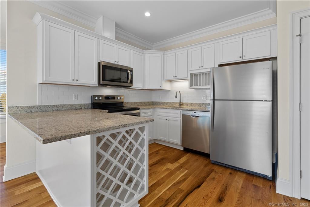 73 West Main Street, Unit 5 Clinton, CT 06413 - Photo 5 of 23 a kitchen with a sink a refrigerator and cabinets