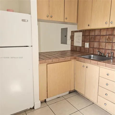 a kitchen with granite countertop white cabinets and stainless steel appliances