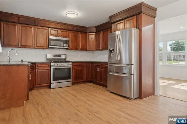 a kitchen with stainless steel appliances granite countertop a refrigerator stove and sink