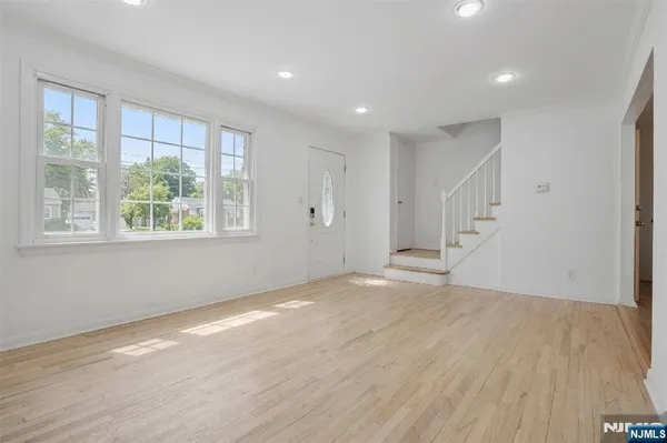 a view of an empty room with wooden floor and entryway