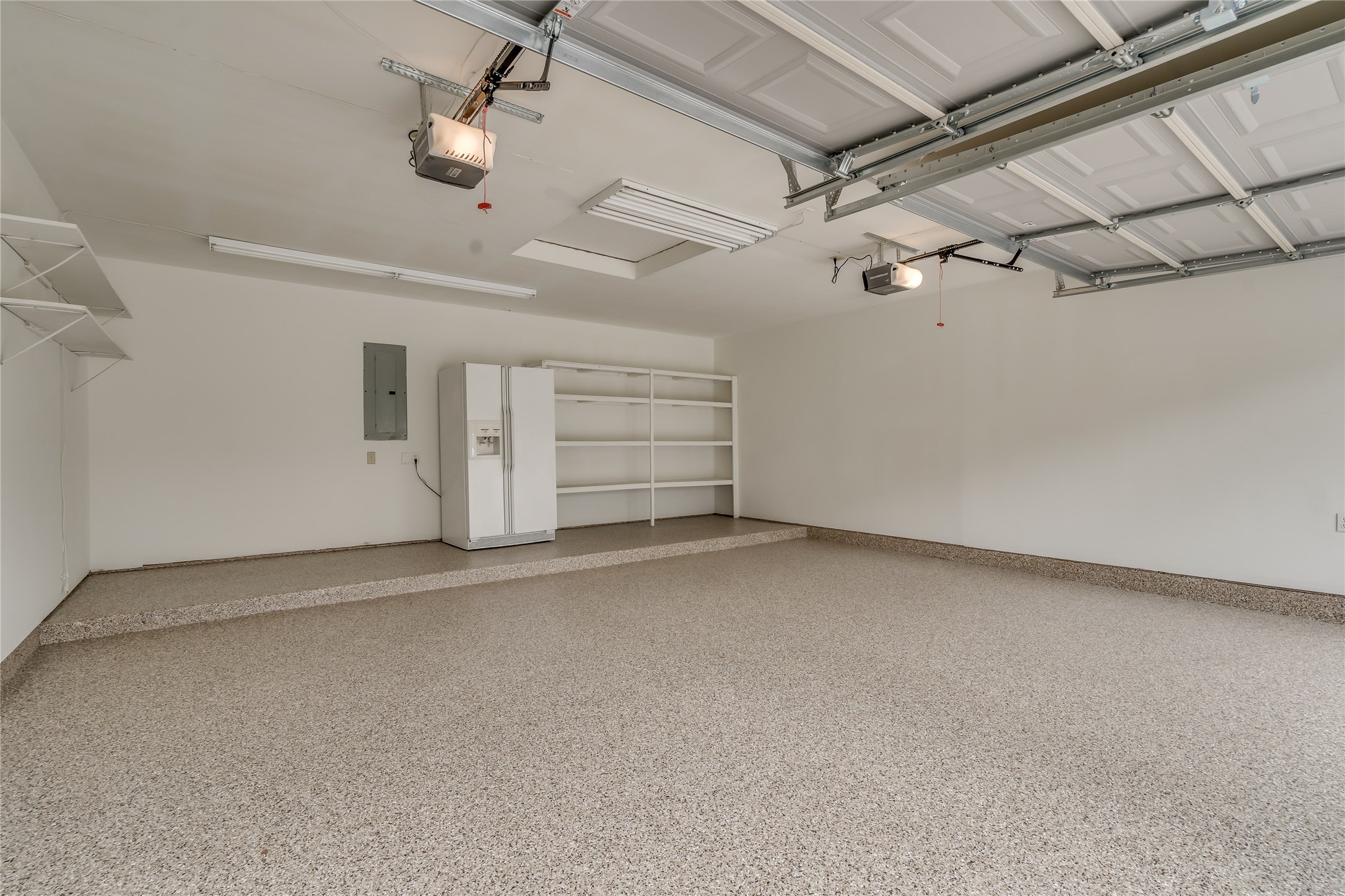 2460 Pebblebrook Circle Conroe, TX 77384 - Photo 23 of 27 2- car garage with extended storage space and epoxy flooring. Refrigerator will remain with the home.