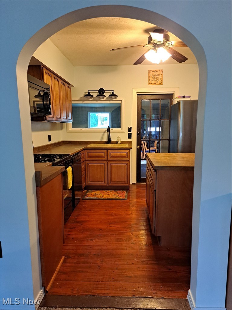 49197 John Tomcho Road Cumberland, OH 43732 - Photo 18 of 50 Kitchen featuring dishwashing machine, ceiling fan, dark hardwood / wood-style flooring, range, and refrigerator