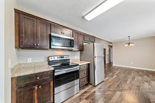 a kitchen with stainless steel appliances granite countertop a sink a stove and cabinets