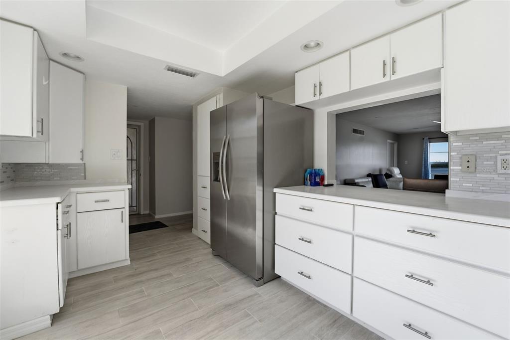 4440 Exeter Drive, Unit 106 Longboat Key, FL 34228 - Photo 5 of 26 a kitchen with cabinets stainless steel appliances and wooden floor