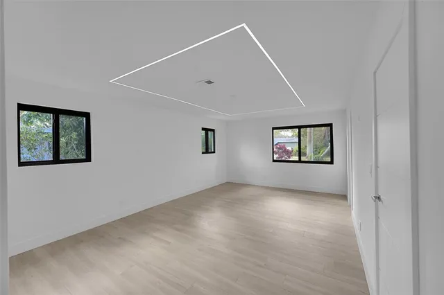 a view of an empty room and a kitchen