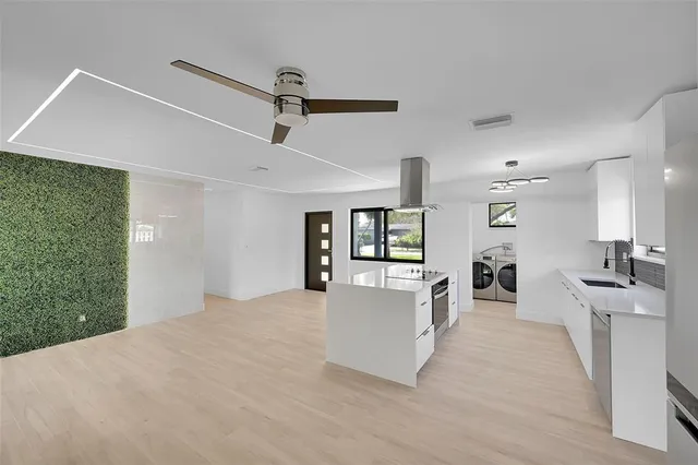 a view of a kitchen with a sink a refrigerator and a fireplace