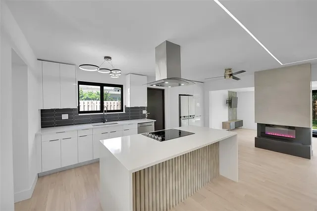 a kitchen with stainless steel appliances kitchen island a sink stove and cabinets