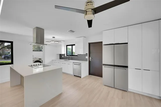 a kitchen with a refrigerator and a stove top oven