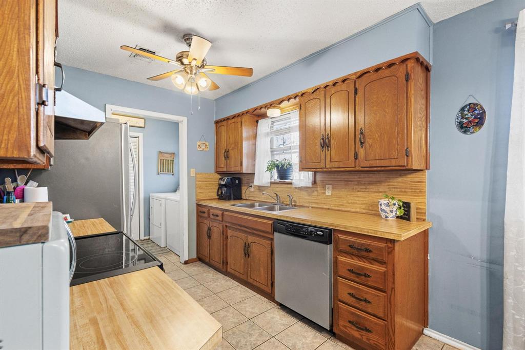 3013 Belle Avenue Denison, TX 75020 - Photo 11 of 32 a kitchen with stainless steel appliances granite countertop a sink dishwasher and a refrigerator with wooden floor