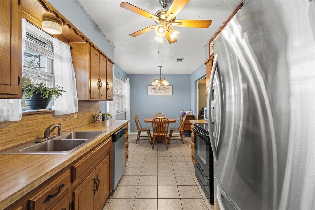 3013 Belle Avenue Denison, TX 75020 - Photo 12 of 32 a kitchen with stainless steel appliances granite countertop a sink a stove and a refrigerator
