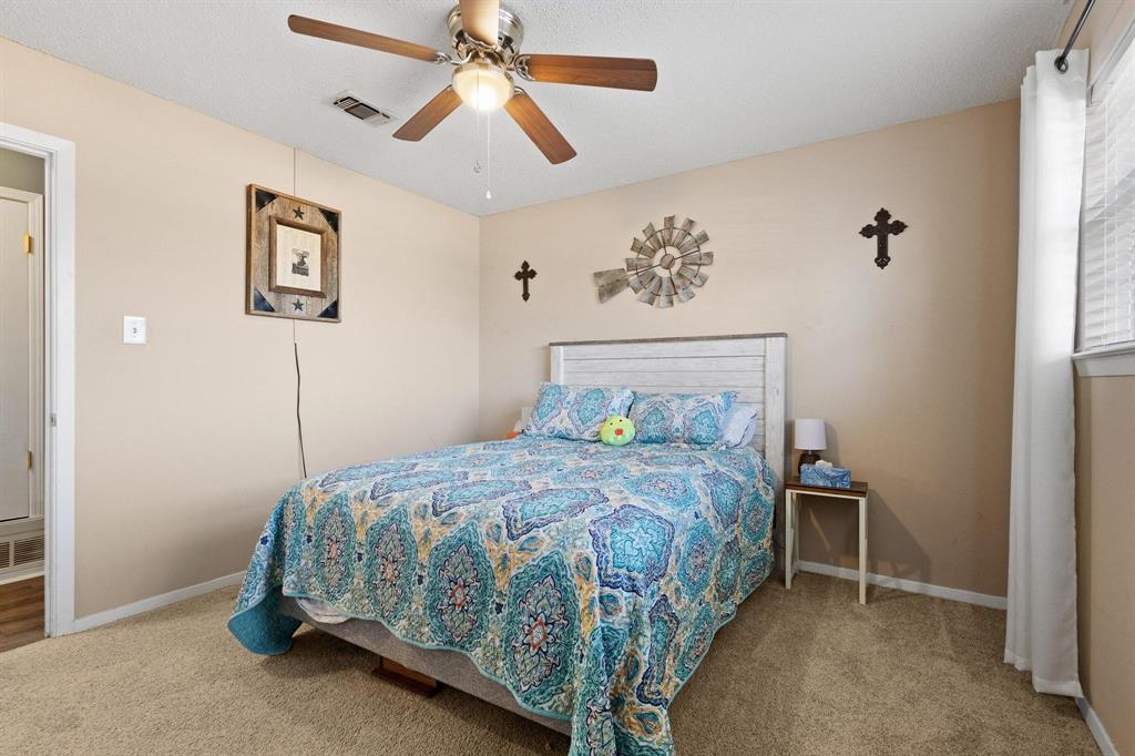 3013 Belle Avenue Denison, TX 75020 - Photo 15 of 32 a bedroom with a bed and a chandelier