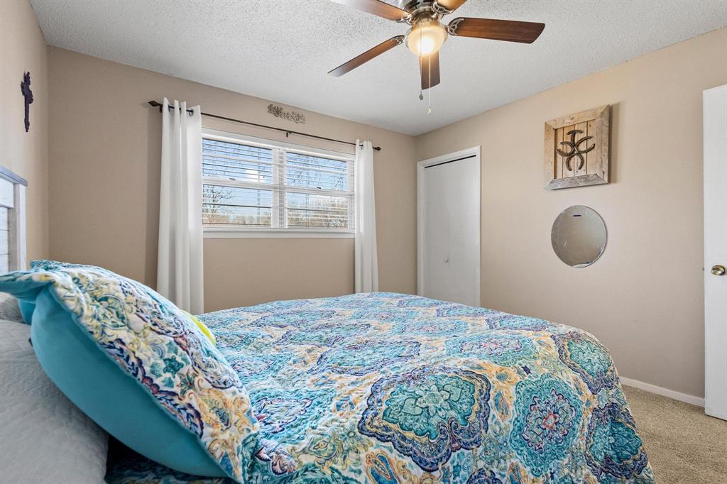 3013 Belle Avenue Denison, TX 75020 - Photo 16 of 32 a bedroom with a bed and a chandelier