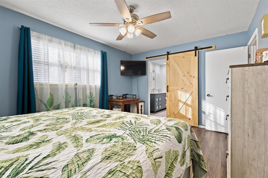 3013 Belle Avenue Denison, TX 75020 - Photo 23 of 32 a bedroom with a bed and a chandelier