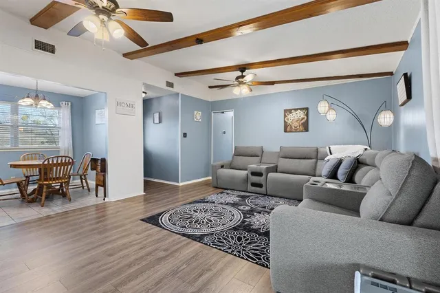 a living room with furniture and a wooden floor