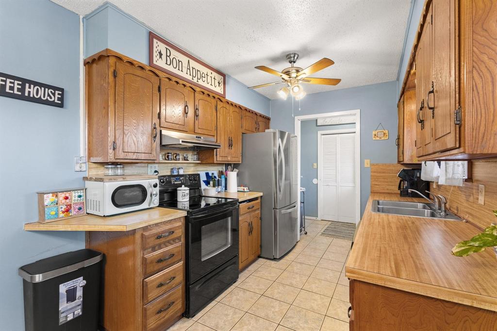 3013 Belle Avenue Denison, TX 75020 - Photo 10 of 32 a kitchen with stainless steel appliances granite countertop a stove a sink and a refrigerator