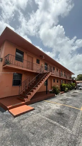 a view of a house with a large window and a car parked in front of it