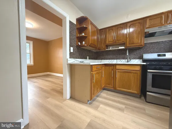 a view of a kitchen with stainless steel appliances granite countertop a stove and a sink