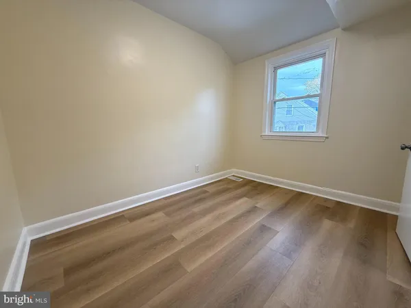 an empty room with wooden floor and closet