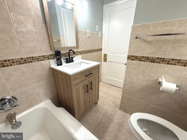 a bathroom with a bathtub a sink and a mirror