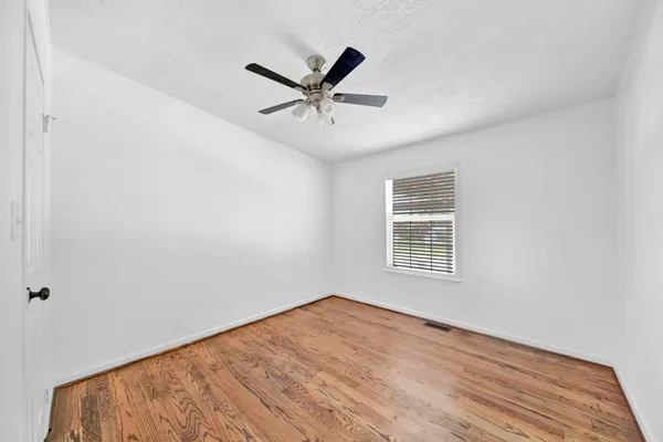 a view of a big room with wooden floor and windows