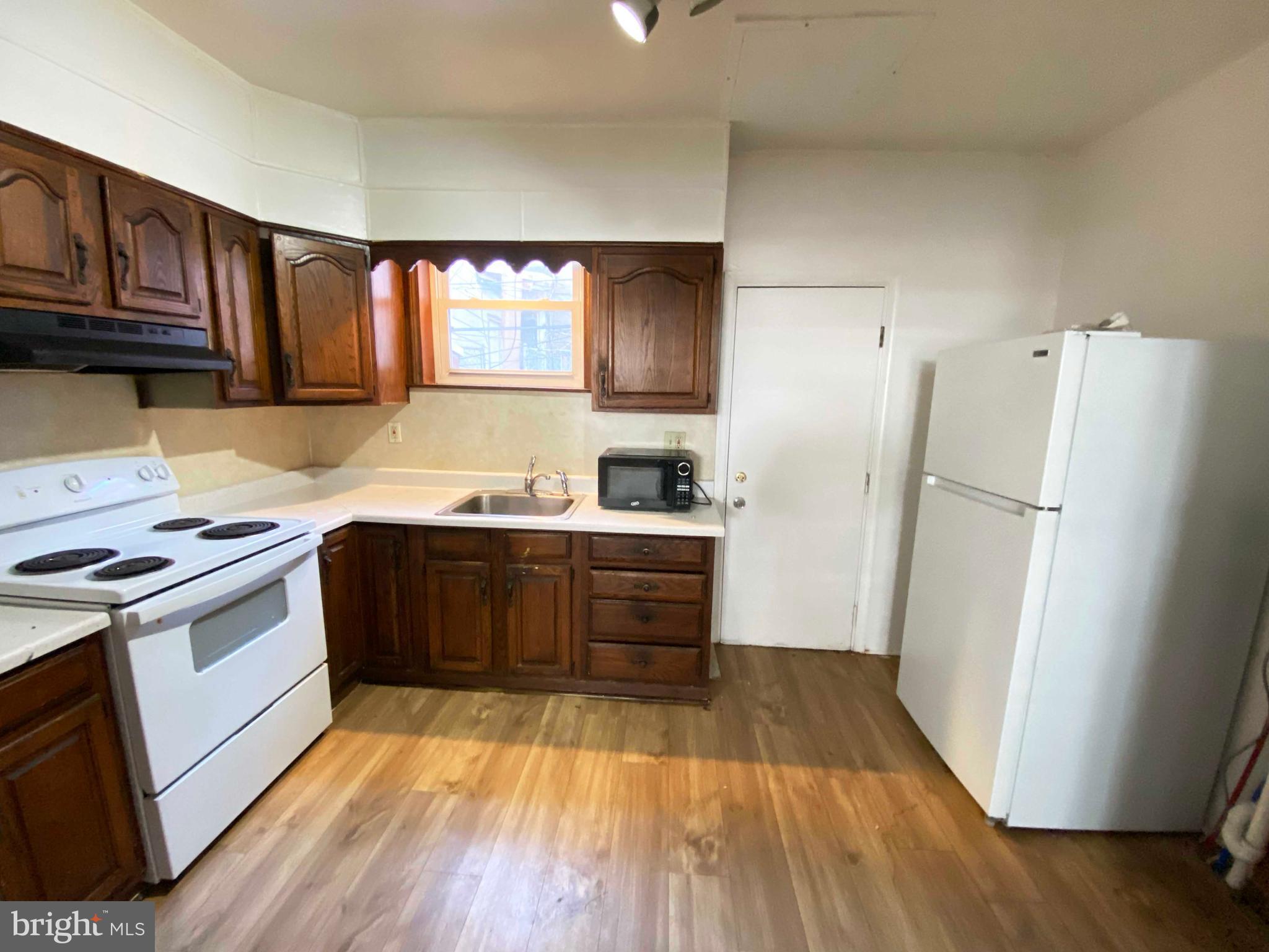 3342 Malta Street Philadelphia, PA 19134 - Photo 14 of 39 a kitchen with wooden floors and refrigerator