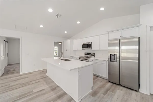 a kitchen with stainless steel appliances a refrigerator sink and stove