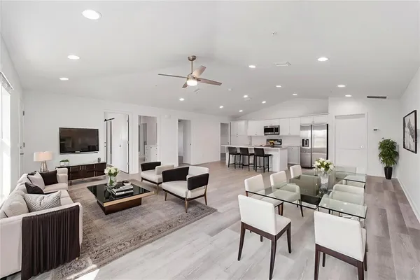 a living room with furniture kitchen view and a flat screen tv