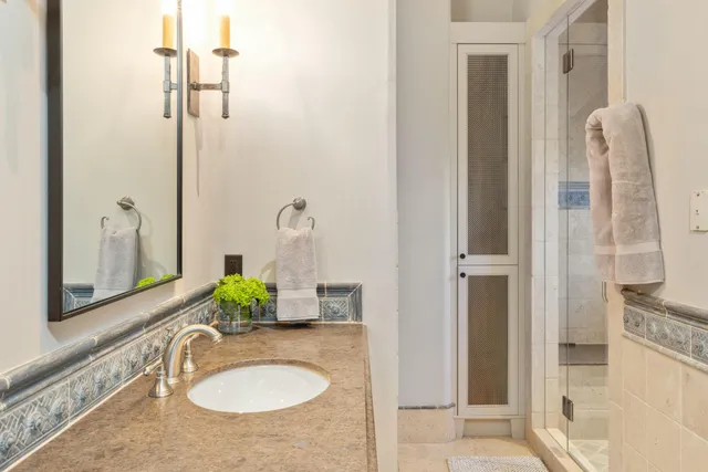 a dining hall with stainless steel appliances kitchen island granite countertop a dining table chairs and a refrigerator