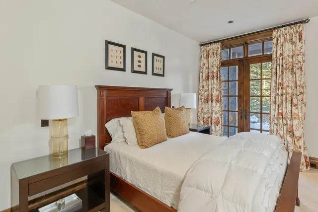 a bedroom with a large bed and windows