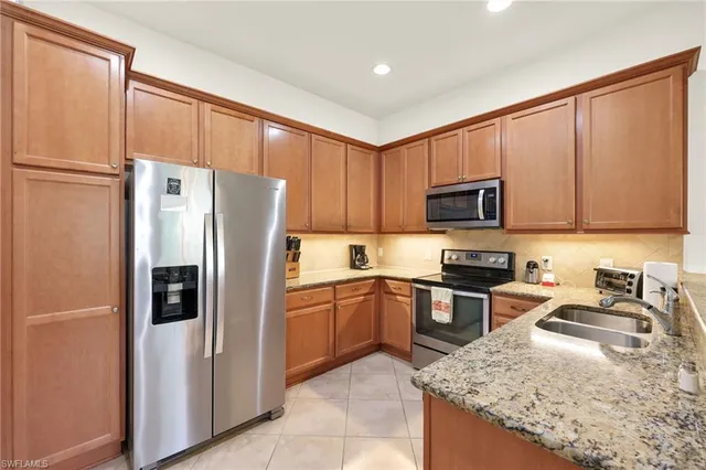 a kitchen with stainless steel appliances granite countertop a refrigerator stove microwave and sink