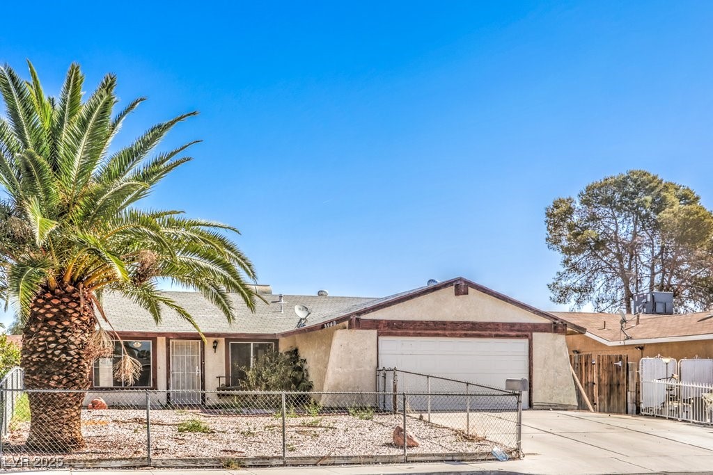 3948 Maple Hill Road Las Vegas, NV 89115 - Photo 1 of 20 Single story home featuring an attached garage, concrete driveway, stucco siding, and a fenced front yard