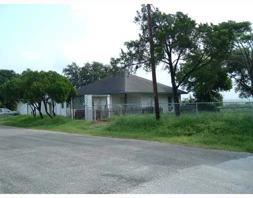 a view of a big house with a big yard and large trees