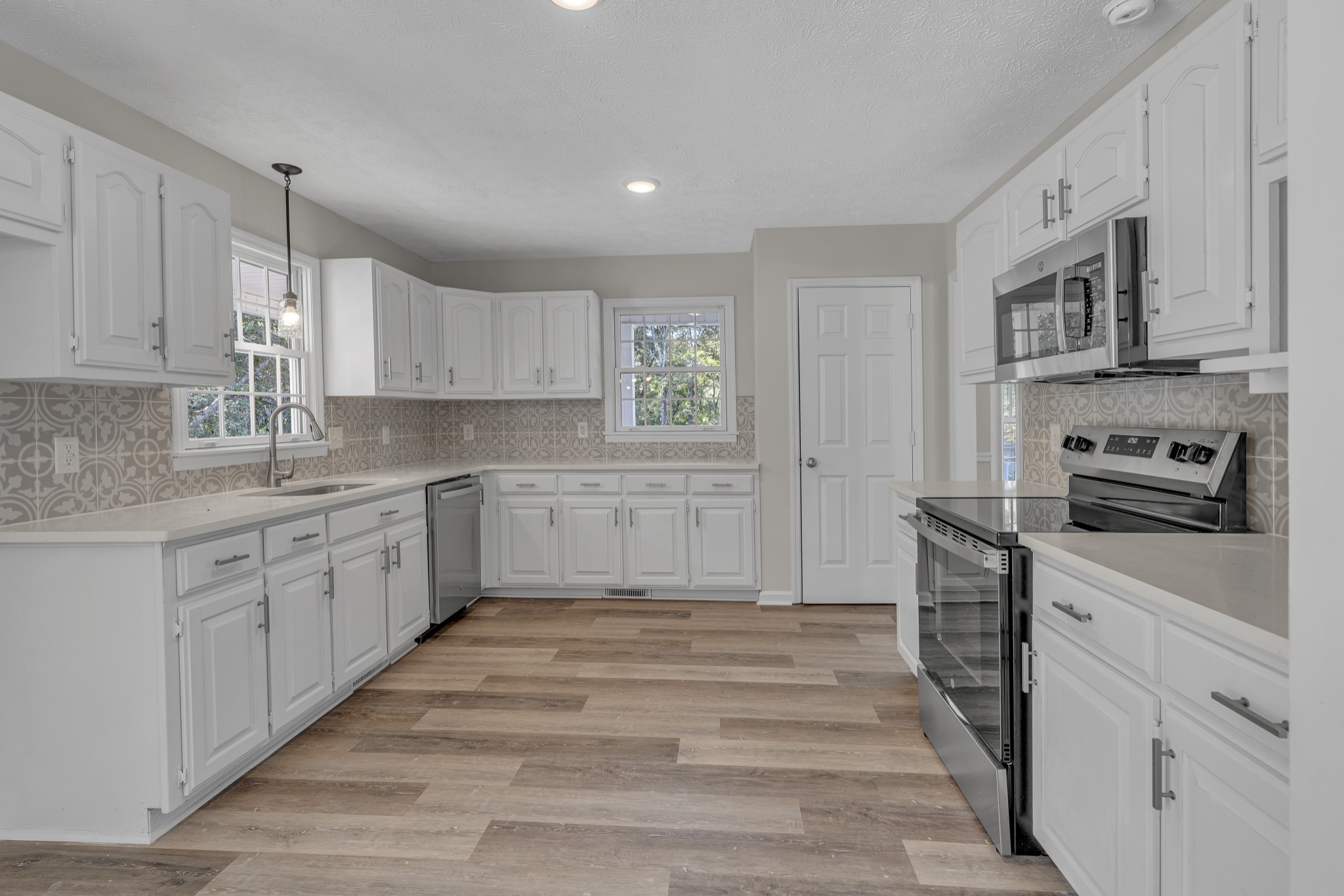 6041 Henry Gower Road Pleasant View, TN 37146 - Photo 19 of 63 a kitchen with stainless steel appliances granite countertop a sink and dishwasher a stove top oven with white cabinets