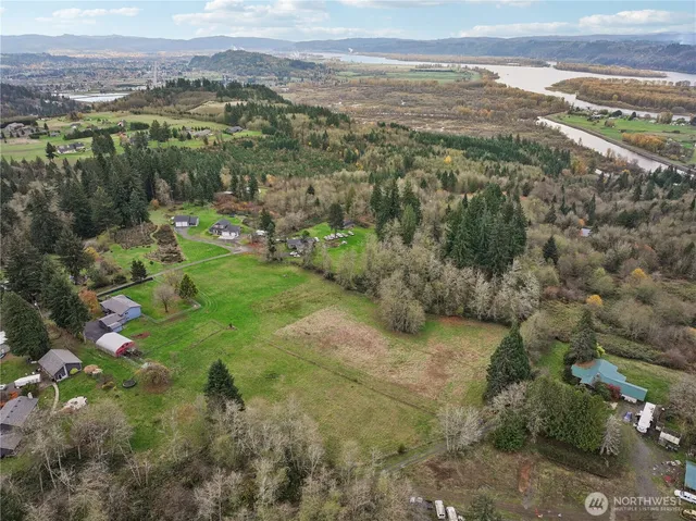 an aerial view of residential houses with outdoor space and trees
