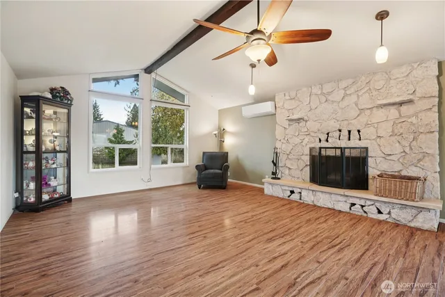 a view of a livingroom with wooden floor and a fireplace