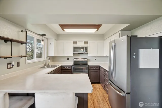 a kitchen with granite countertop a refrigerator stove and sink