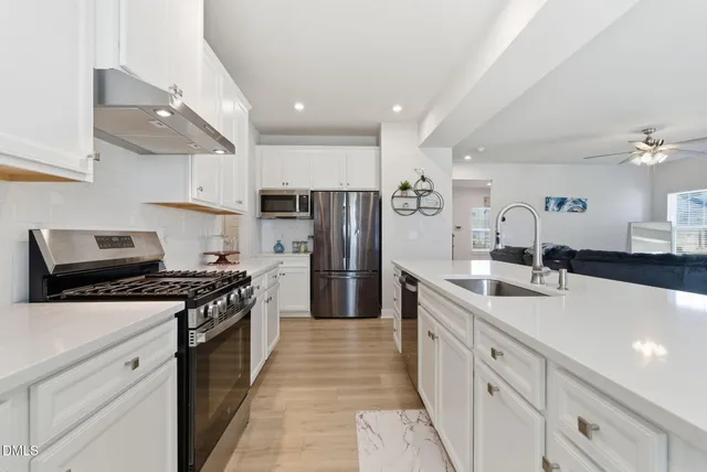 a kitchen with stainless steel appliances a refrigerator a stove a microwave and cabinets