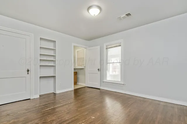an empty room with cabinet and a window