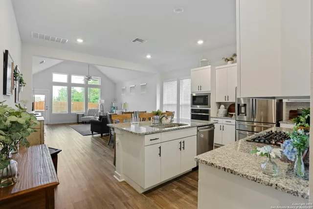 a kitchen with sink stove and refrigerator