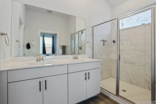 a bathroom with a shower sink and mirror