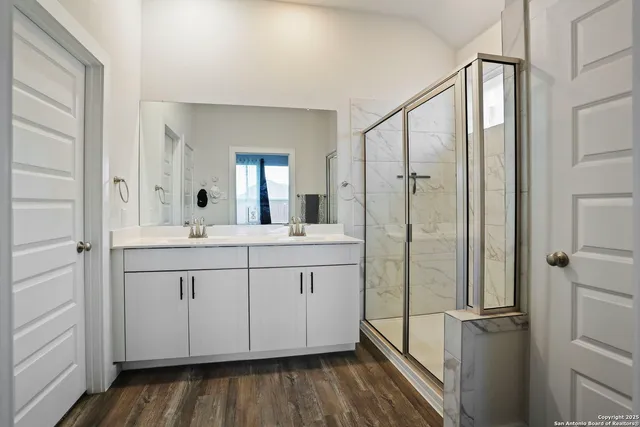 a spacious bathroom with a shower sink and mirror