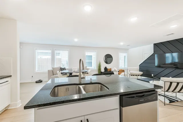 a kitchen with a sink and a stove top oven with wooden floor